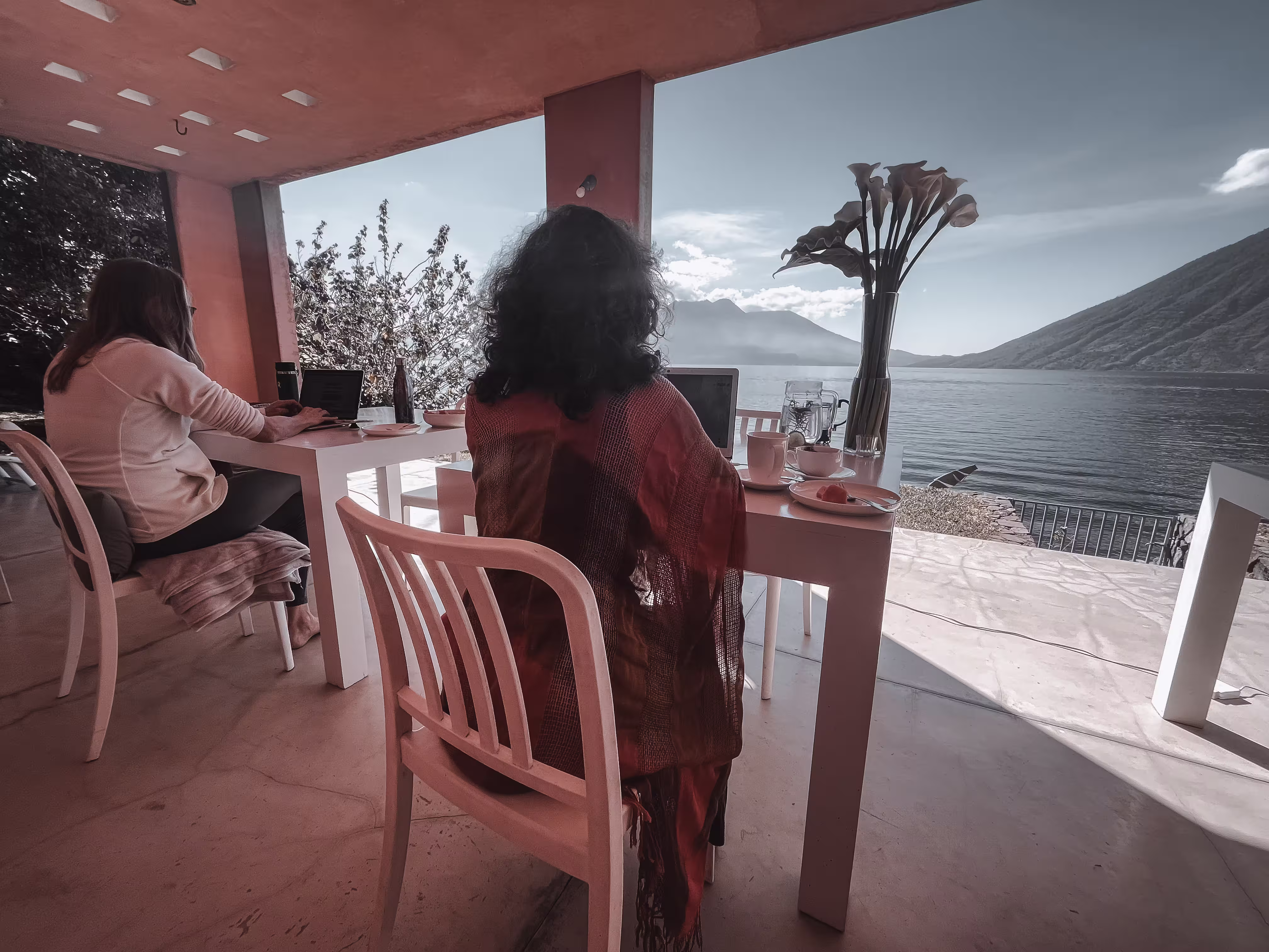 People gathered around a table overlooking a lake.