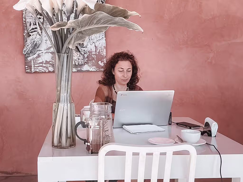 A woman working on a laptop at a table.