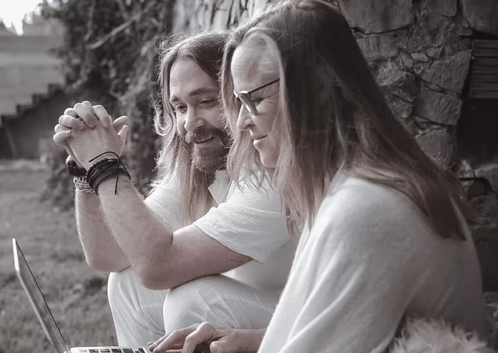 Two people reviewing work together on a laptop