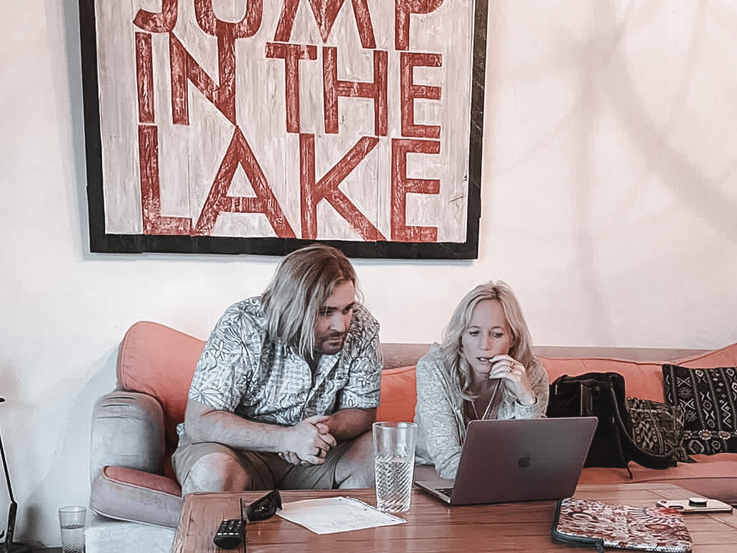 Two people reviewing work together at a laptop.