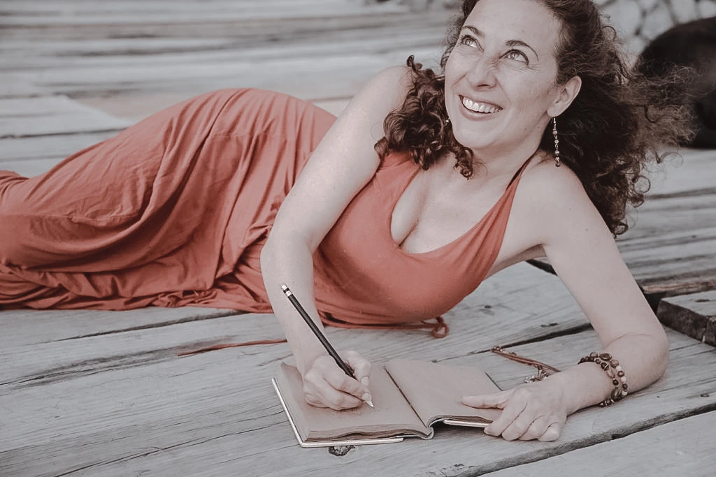 A woman writing by hand in a notebook.
