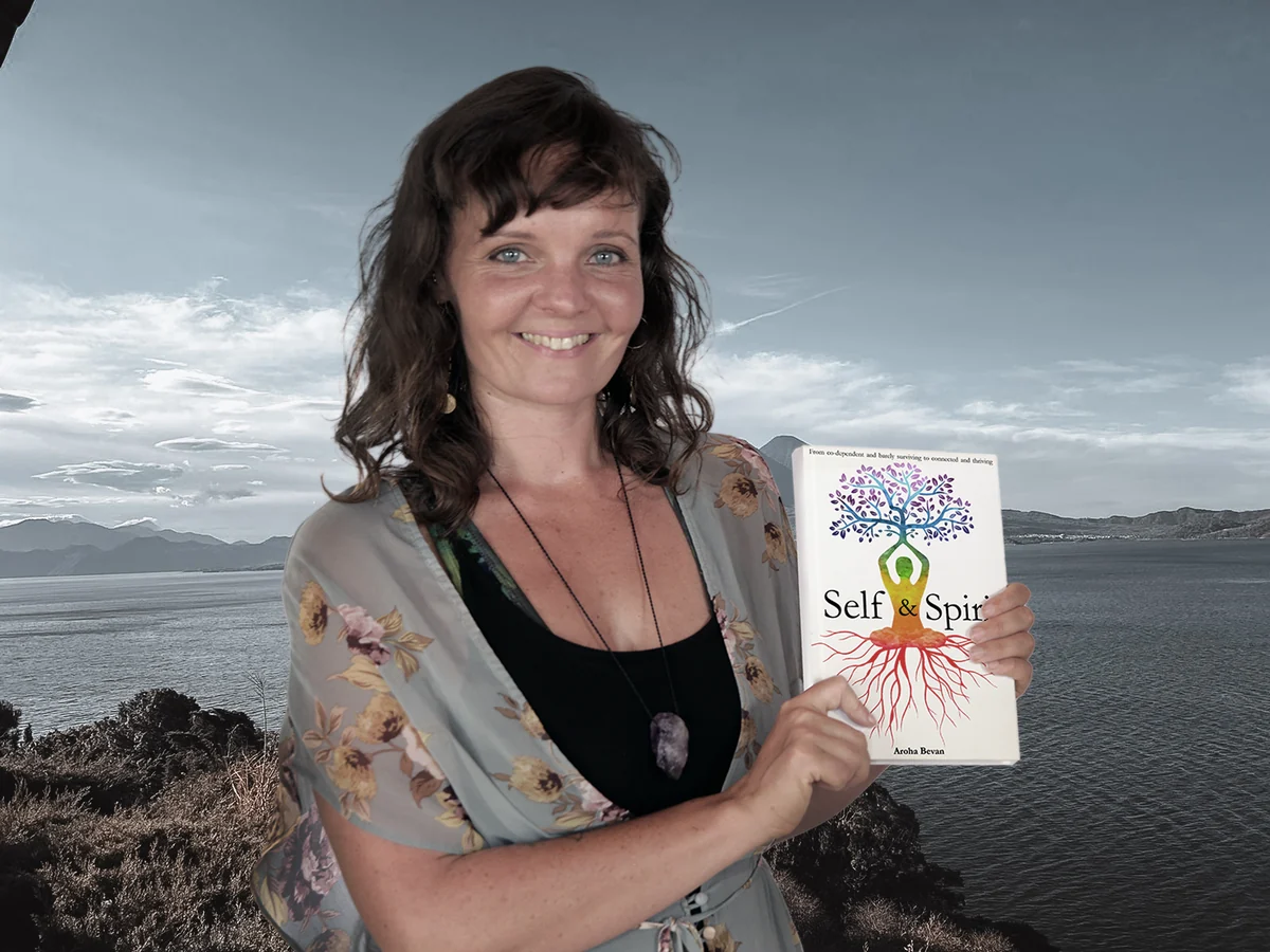 An author holding her published book as an example of completed work.