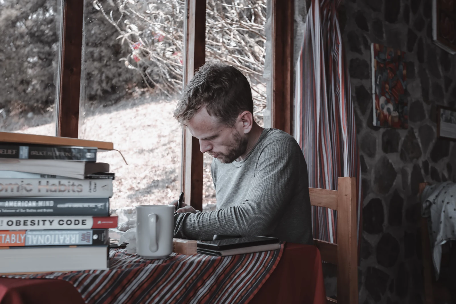 An author reviewing pages while working at a laptop.
